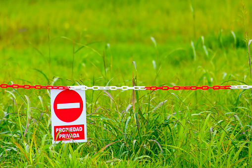 Signs on a wooden farmyard gate warning that the area is private farmland and that entry is forbidden. Another sign in yellow warns that CCTV security is in operation.