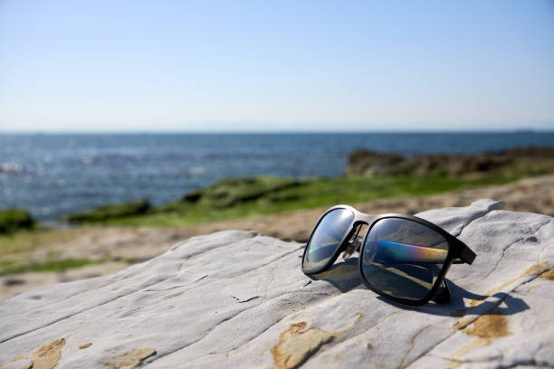istock [Minamichita] Sunglasses placed on a rocky area on the coast 2072675992