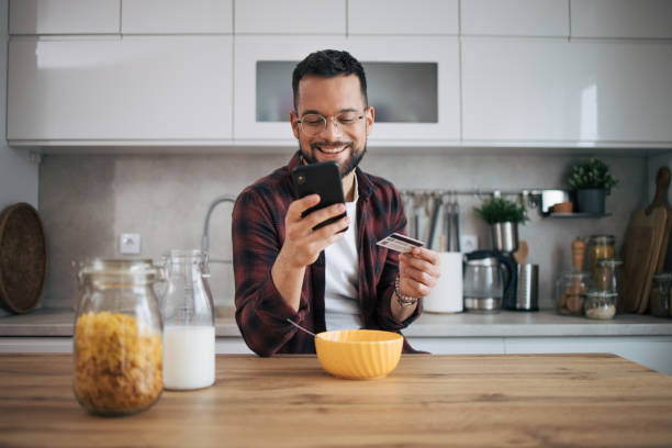 istock A man is shopping online in his kitchen. 2072686428
