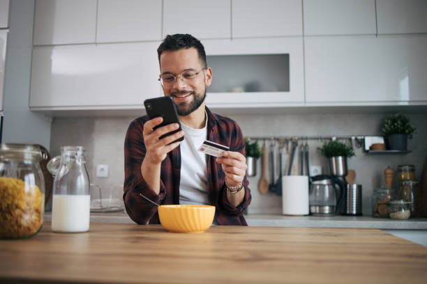 istock A man is shopping online in his kitchen. 2072689512