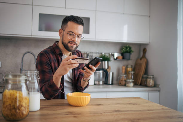 istock A man is shopping online in his kitchen. 2072690559