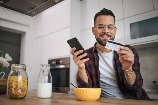 istock A man is shopping online in his kitchen. 2072691072