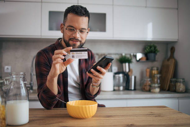 istock A man is shopping online in his kitchen. 2072692144