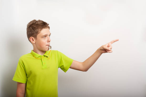 a teenage boy with a whistle looks like a sports coach or referee