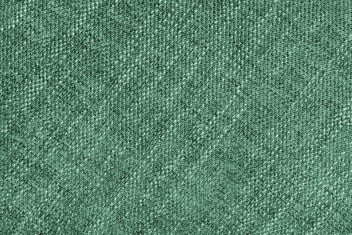 Coarse weave jacquard fabric texture background, green cloth texture. Textile background, furniture textile material, wallpaper, backdrop. Textile structure close up.