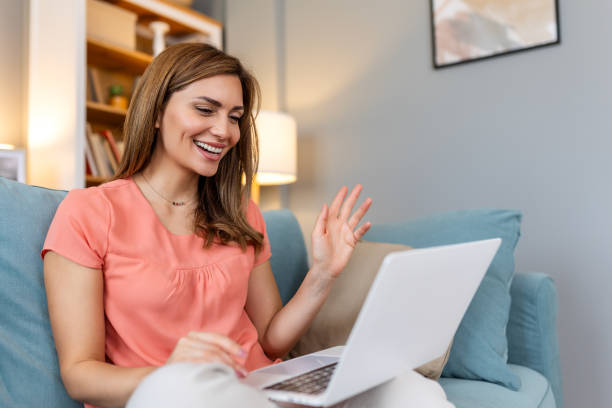 istock Young woman using laptop at home, looking at screen, chatting, reading or writing email, sitting on couch, female student doing homework, working on research project online 2072777596