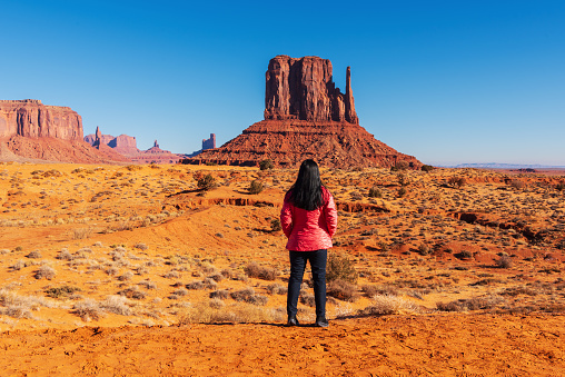 A tourist woman  enjoys view of Merrick Butte in Monument Valley in USA . Travel in the winter in Arizona