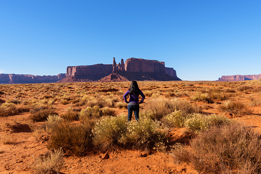 Woman hiker enjoying the view of the sandstone formations in Monument Valley Navajo Tribal Park in southern Utah