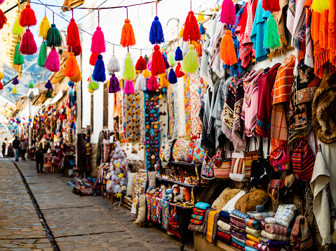 Colorful alley with handmade souvenirs in traditional Pisac market, Sacred valley of Inca, Cusco region, Peru