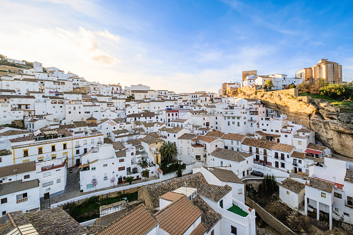 Panoramic view of Setenil de las Bodegas, a town along the narrow river gorge of the Rio Trejo with some houses being built under or into the rock walls of the gorge itself