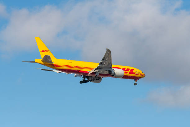 n773ck - boeing 777-f - dhl airline lecący na zachmurzonym popołudniowym niebie - c._k. zdjęcia i obrazy z banku zdjęć
