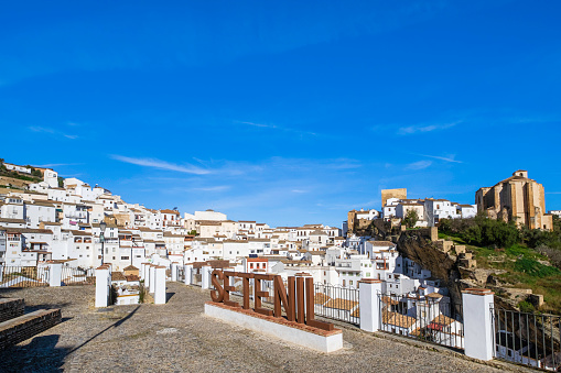 Panoramic view of Setenil de las Bodegas, a town along the narrow river gorge of the Rio Trejo with some houses being built under or into the rock walls of the gorge itself