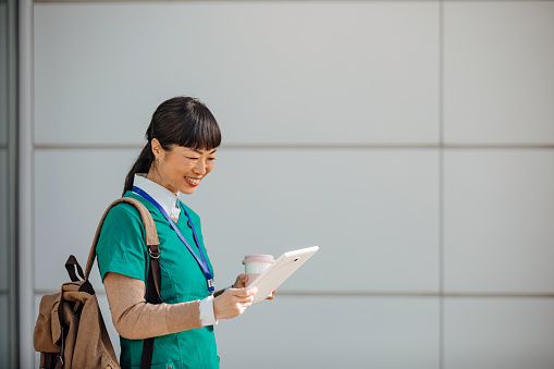 With a digital tablet in hand, a mature Chinese medical nurse charts the future of healthcare outdoors, leveraging technology to streamline processes, improve patient communication, and set new standards in nursing excellence