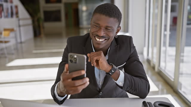 African american businessman using smartphone in modern office setting