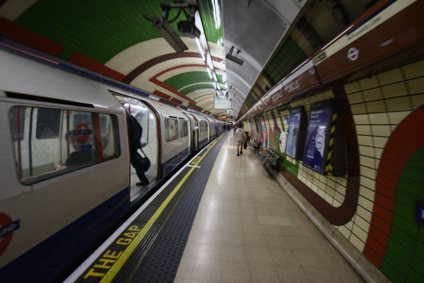 London tube train at Piccadilly Circus station before departing. The image shows a tube train with several commuters at the platform.