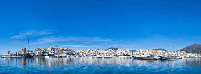 Yachts moored at the marina of Puerto Banús, a luxury resort and shopping complex in the Costa del Sol with beaches and marina, built in 1970 (10 shots stitched)