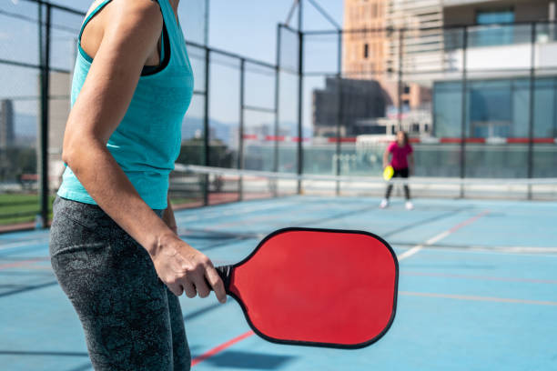 패들은 여자 손이고 전경에 또 다른 여성 피클볼 선수는 배경 수평 피클볼 스틸입니다 - paddle ball racket ball table tennis racket 뉴스 사진 이미지