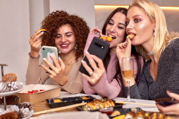 istock Discussing the latest gossips. Three beautiful young women talking and smiling while drinking wine and sitting on the couch together 2072907828