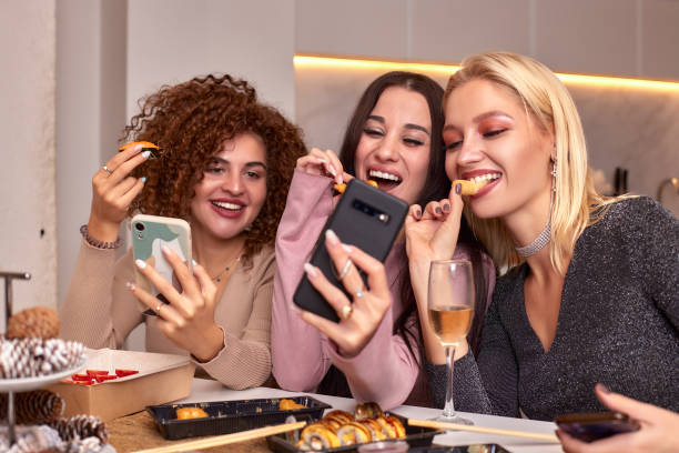 istock Discussing the latest gossips. Three beautiful young women talking and smiling while drinking wine and sitting on the couch together 2072911458