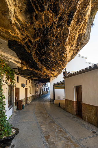 Alley in the old town of Setenil de las Bodegas, a town along the narrow river gorge of the Rio Trejo with some houses being built under or into the rock walls of the gorge itself