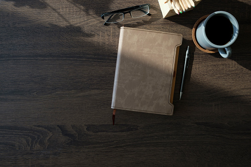 Above view simple workplace with books, coffee cup and pencils on wooden table.