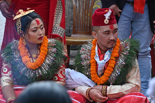 Kirtipur, Nepal - February 12, 2024 - A Newari Wedding starts with the ritual of, the groom side sending twelve areca nut in a huge silver bowl along with fruits, sweets, gold jewelry, clothes and other cosmetic accessories for the bride which are decorated and displayed in trays in an eye-catching way. The groom and the groom’s mother is absent in this ceremony whereas the bride’s mother starts the ceremony by worshipping lord Ganesh, lord of fire(Agni devta) and other god and goddesses. This ritual is usually performed four days before the wedding on the same day as the bride side’s reception party.