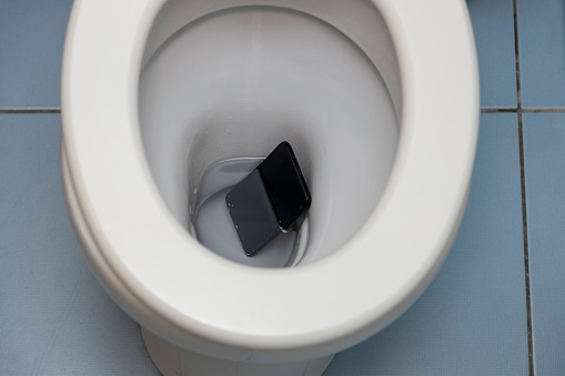 Smartphone Fallen into the Toilet Bowl. Wet and under water.