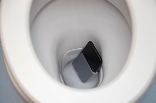 Smartphone Fallen into the Toilet Bowl. Wet and under water.