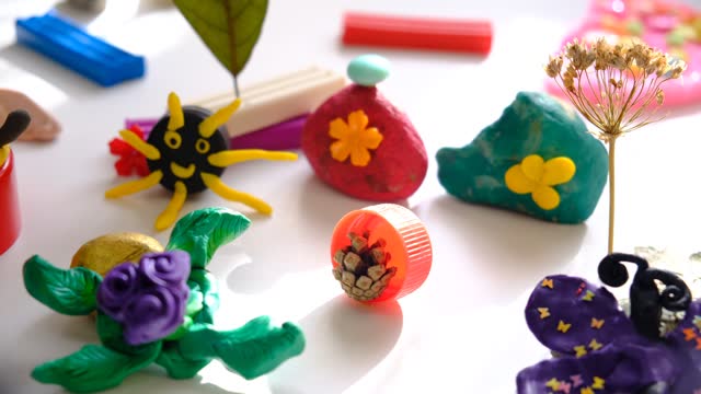 Child making crafts using natural dry plants, flowers, grass, leaves and use plastic corks, stones, plasticine, beads and paper. Back to school. Making diorama. Ideas for children's art