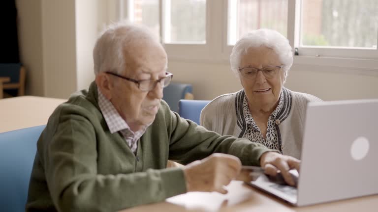 Senior people shopping online using credit card and laptop