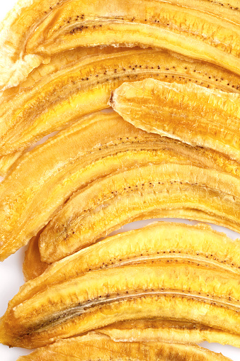 Dried banana slices. Sliced dried banana isolated on white background. Sun-dried fruit. close up.