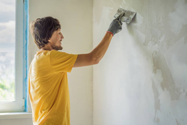 istock Plasterer home improvement handyman worker with putty knife working on apartment wall filling 2073068321