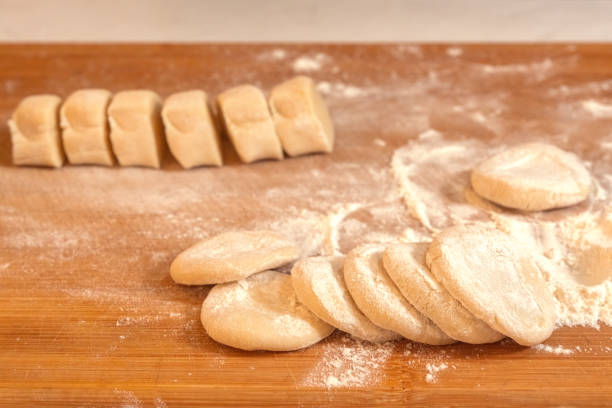 istock Pieces of dough sprinkled with flour for rolling into thin flat cakes. Close-up 2073086379