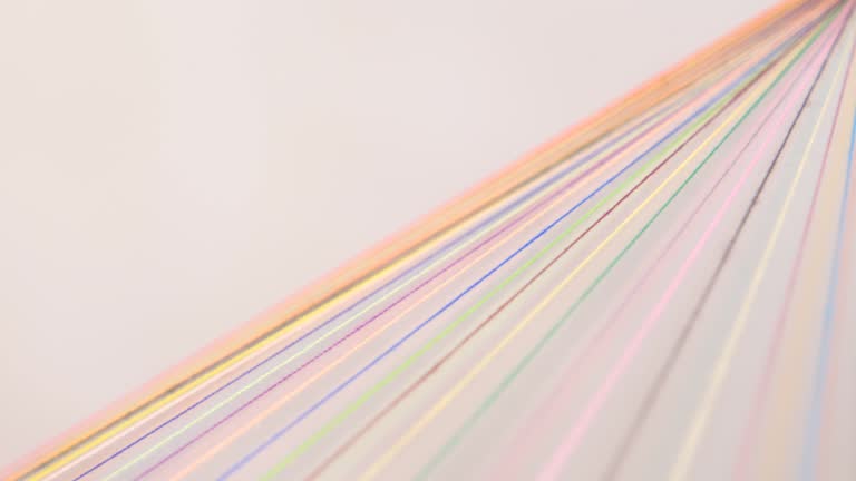 Rainbow Colored Threads Converge Through Needle Eyelet on a rotating table