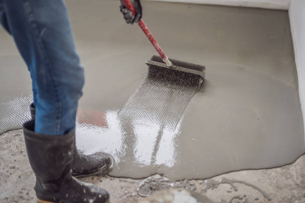 plasterer during floor covering works with self-levelling cement mortar, uses a needle roller