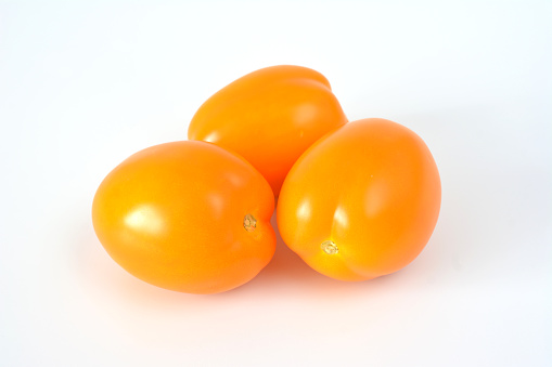 group of orange oval tomatoes isolated on white background