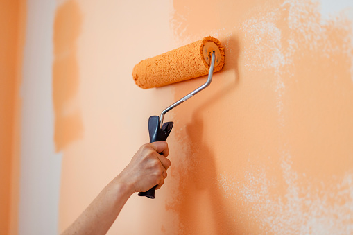 Hand of Woman Painting With Paint Roller on Wall in Apartment. Home Decoration Concept