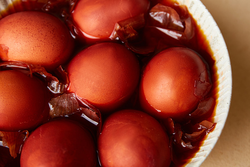 Chicken eggs in a decoction of onion husks. Coloring eggs in natural dyes for the Easter holiday. Close-up