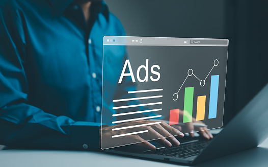 Ad on website and social media, banner ads on internet, Digital marketing concept. Marketer analyzing online advertising campaigns and performance metrics on a laptop with a graphical data interface.