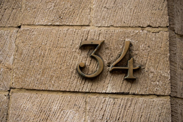 istock metallic number 34 on stoned wall of building 2073139324