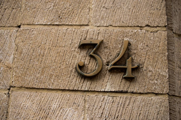 metalowa cyfra 34 na kamiennej ścianie budynku - cyfra_  zdjęcia i obrazy z banku zdjęć
