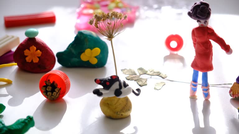 Child making crafts using natural dry plants, flowers, grass, leaves and use plastic corks, stones, plasticine, beads and paper. Back to school. Making diorama. Ideas for children's art