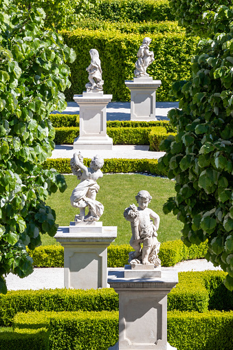Row of white baroque statues of allegorical putti in public park in Bratislava