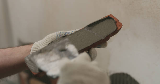 istock closeup worker applying concrete glue to brick cuts tile 2073185230