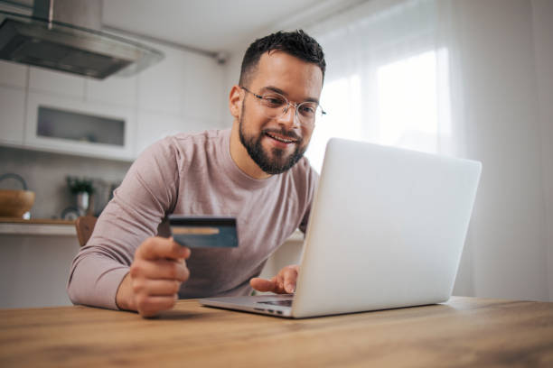 istock A man uses a laptop computer and a credit card. 2073224460