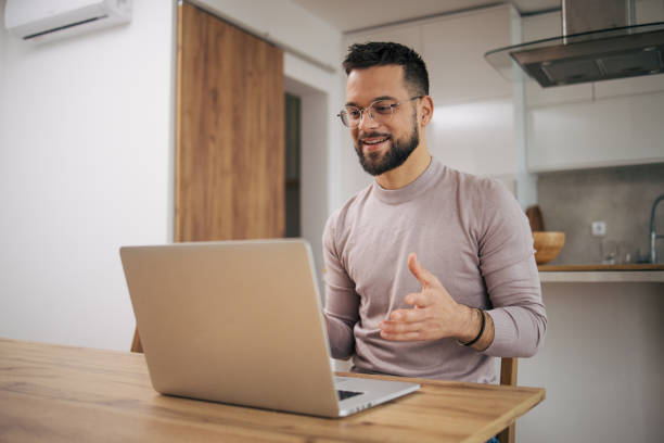 istock An attractive man is talking on a video call. 2073228124