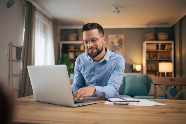 istock adult man work from home online. 2073236706