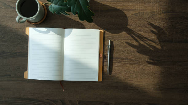 istock Flat lay notebook, coffee cup and potted plant on wood office desk. 2073238357