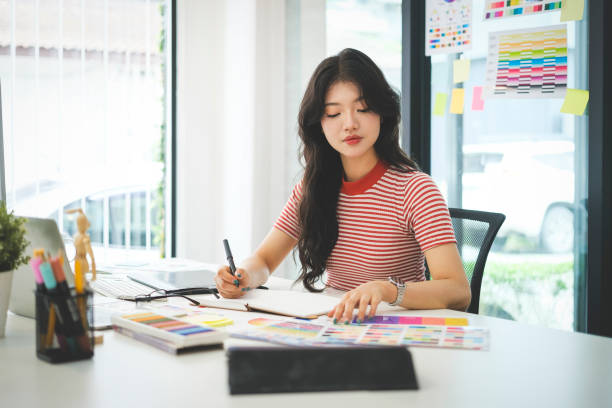istock Young female graphic designer working with modern computer and color swatch samples. 2073239476