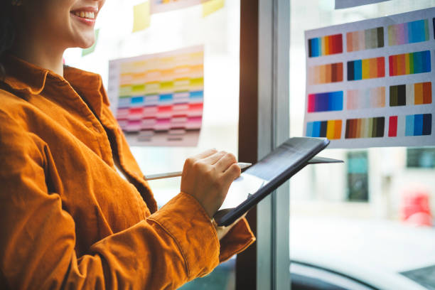 istock Young creative woman working on color selection and drawing on digital tablet at workplace. 2073240564